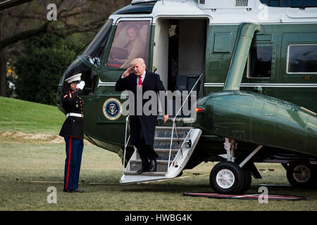 Washington, USA. 19th Mar, 2017. United States President Donald Trump salutes as he disembarks from Marine One on the South Lawn of the White House in Washington, District of Columbia, U.S., on Sunday, March 19, 2017. President Trump is returning from a weekend at his Mar-a-Lago resort in Palm Beach, Florida. Credit: MediaPunch Inc/Alamy Live News Stock Photo