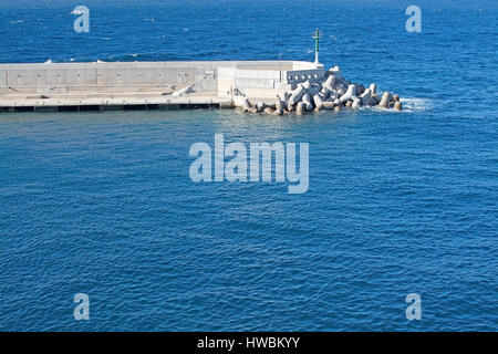 Stone jetty and blue ocean on a sunny day in Mallorca, Balearic islands, Spain. Stock Photo