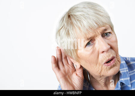 Studio Shot Of  Senior Woman Suffering From Deafness Stock Photo