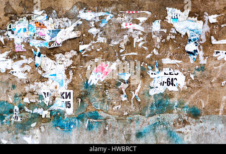 Old weathered grunge brick wall with scraps of old paper as background Stock Photo