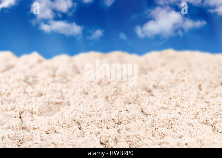 Wet sand is sharp in the foreground and blurred in the distance on a background of blue sky Stock Photo