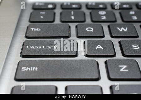 Modern laptop keyboard closeup. Caps Lock key. Shallow depth of field. Stock Photo