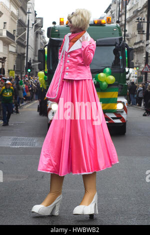 Woman wearing neon pink dress on stilts for the St. Patricks day parade Stock Photo