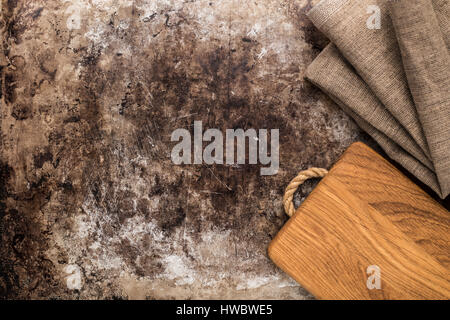 Wooden chopping board and kitchen towel on old rustic table Stock Photo
