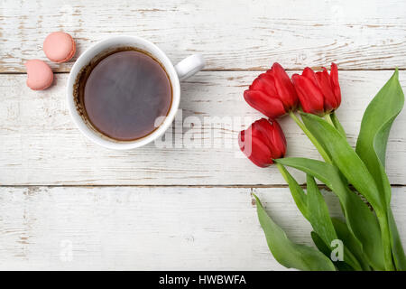 Red tulips, coffee cup over white wood table. Flat lay Stock Photo