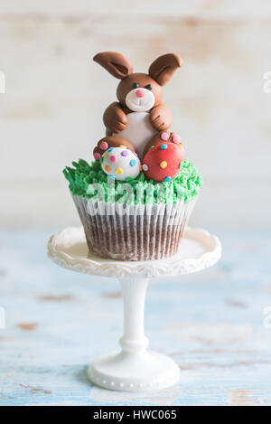 Bunny with Easter eggs on the top of cup cake,selective focus Stock Photo