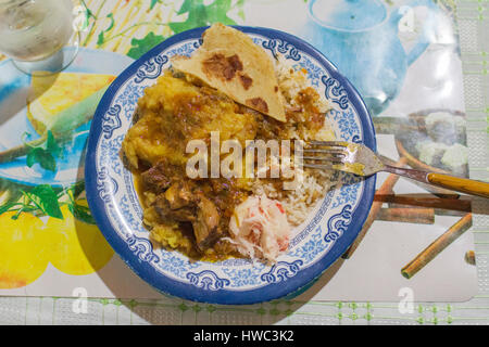 A traditional Ugandan dish containing streamed and mashed matoke (food bananas), rice, stew of goats meat and a chapati on the side. Matoke is the traditional stabile food from the southern Masaka region, but is now eaten over the most of sub-Nile Uganda. Chapati is mostly known as an Indian food pancake but is has been made in East Africa for many years, just with another recipe. Stock Photo