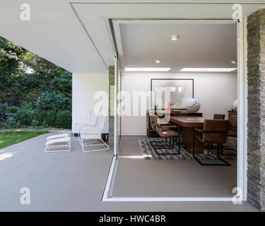View of extension doors and dining area. Private House, Roydon, United Kingdom. Architect: Clear Architects, 2016. Stock Photo