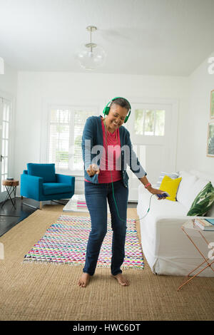 Senior woman listening to music on headphones Stock Photo