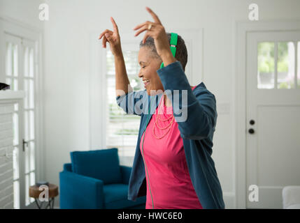 Senior woman listening to music on headphones Stock Photo