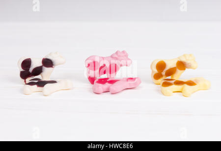 Candies in the form of a multicolored gummy cows on wooden white table Stock Photo