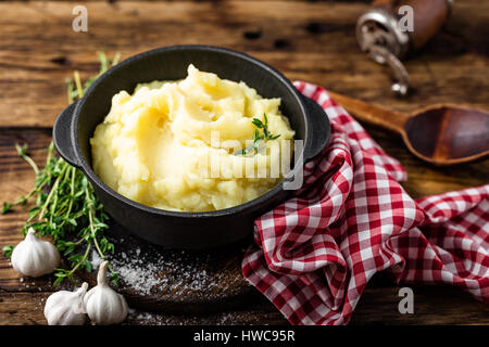 Mashed potatoes, boiled puree in cast iron pot on dark wooden rustic background Stock Photo