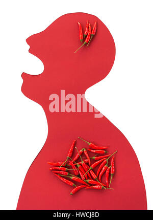 the contour of the person cut from red paper on a white background with an open mouth and hot red peppers lying inside him. concept of heartburn, gastritis, spicy food, strong ilness. flat lay. Stock Photo