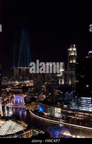 Vertical aerial view of the laser lights shining off the Marina Bay Sands Hotel in Singapore at night. Stock Photo