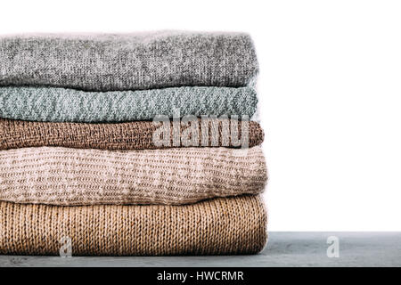 Pile of knitted winter clothes on table Stock Photo
