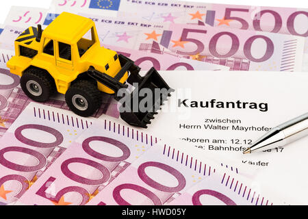 The bill of sale for a new excavator. With euromoney and ballpoint pen, Der Kaufvertrag fuer einen neuen Bagger. Mit Eurogeld und Kugelschreiber Stock Photo