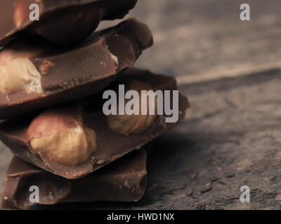 Close up of stacked chocolate bars on a wooden table, vintage color toned Stock Photo