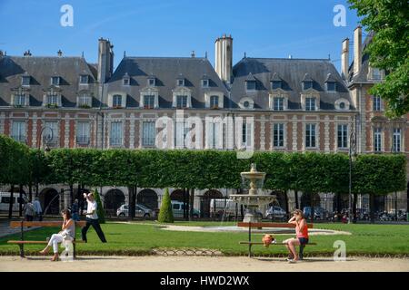 France, Paris, Place des Vosges, young women sitting on benches with a man doing Tai Chi in the background Stock Photo