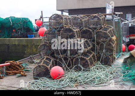Lobster pots piled on the quayside in Kinsale Harbor in County Cork on the southwest coast of Ireland Stock Photo
