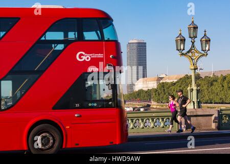 United Kingdom, London, Westminster district, Westminster Bridge, modern towers and couple jogging on the sidewalk, red double decker bus Stock Photo