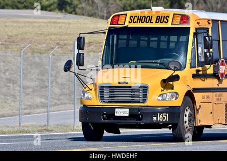 School bus driving down the road Stock Photo