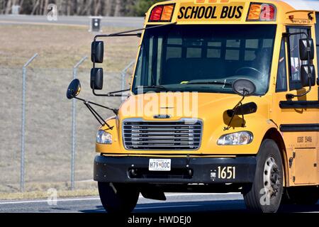 School bus driving down the road Stock Photo