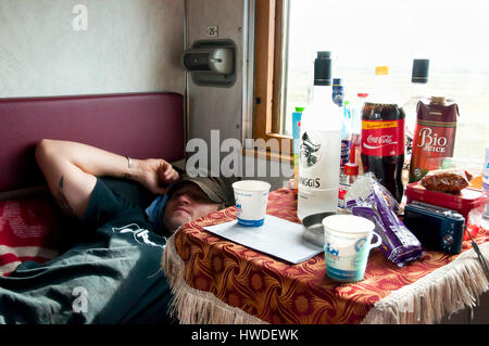 SIBERIA, RUSSIA - May 14, 2012: Tired passenger in a cabin on-board the trans-Siberian train from Beijing to Moscow Stock Photo