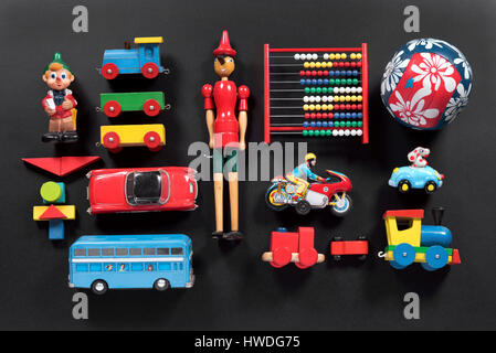 High angle view studio shot of a colorful collection of cute vintage toys both wooden and metallic with copy space on dark gray background Stock Photo