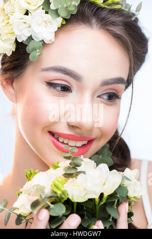 portrait of smiling woman holding flowers bouquet and looking away Stock Photo