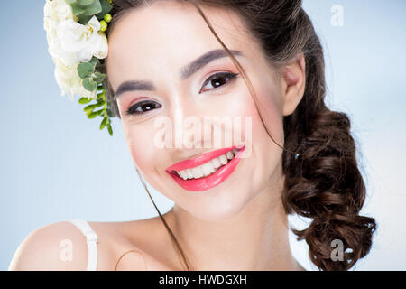 portrait of smiling woman with flowers in hair looking to camera Stock Photo