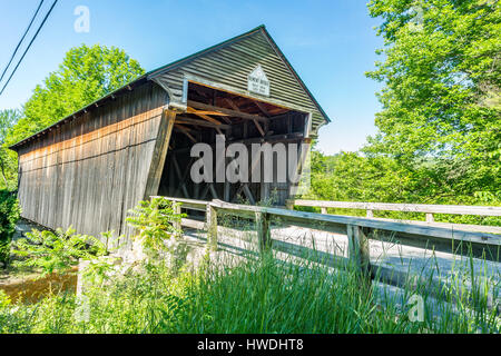 The Bement Covered Bridge, a long truss bridge, is a historic wooden covered bridge on Center Road over the Warner River in Bradford, New Hampshire. Stock Photo