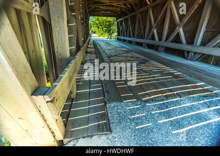 The Bement Covered Bridge, a long truss bridge, is a historic wooden covered bridge on Center Road over the Warner River in Bradford, New Hampshire. Stock Photo