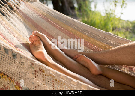 Couple relaxing in hammock, view of legs Stock Photo