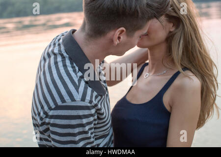 Couple kissing by river Stock Photo
