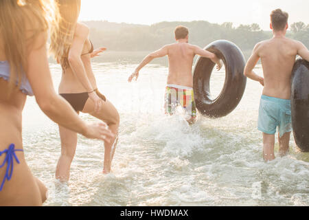 Friends having fun with inflatable ring in river Stock Photo