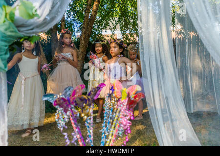 Group of young girls dressed as fairies, playing outdoors