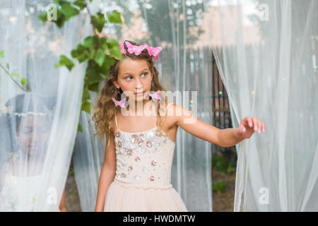 Portrait of young girl dressed as fairy, walking through sheer material Stock Photo