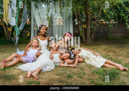 Portrait of mature woman with group of young girls, dressed as fairies, outdoors Stock Photo