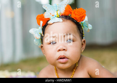 Portrait of baby girl wearing butterflies and flowers in her hair Stock Photo