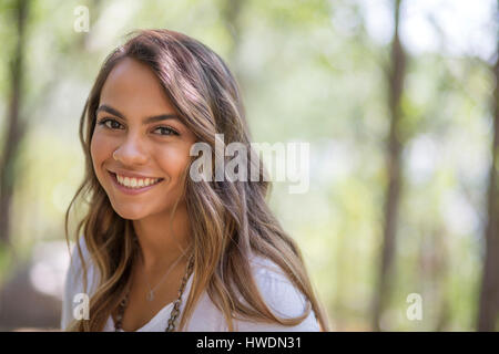 Head and shoulder portrait of pretty long haired teenage girl in woodland Stock Photo