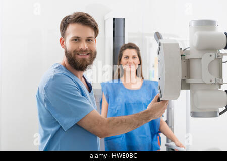 Radiologist Adjusting X-ray Machine Over Female Patient In Hospi Stock Photo