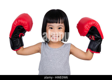 Chinese little girl wearing boxing glove showing power in isolated white background. Stock Photo