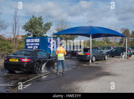 Cars Being cleaned at a Hand Car Wash  Unit in a Car Park in Poole, Dorset, UK Stock Photo