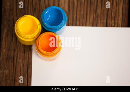 Watercolor paints and white paper on wooden table Stock Photo