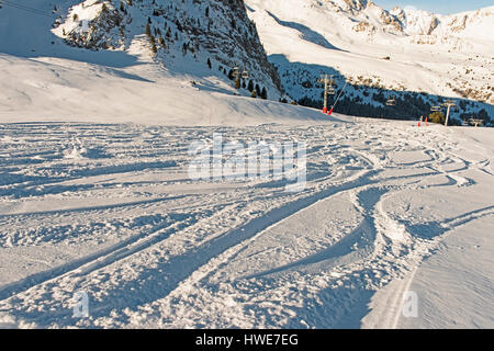 Ski slope piste in winter alpine mountain resort with powder snow tracks Stock Photo