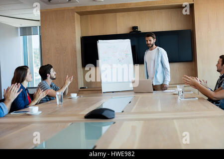 Creative business team applauding while attending a presentation in office Stock Photo