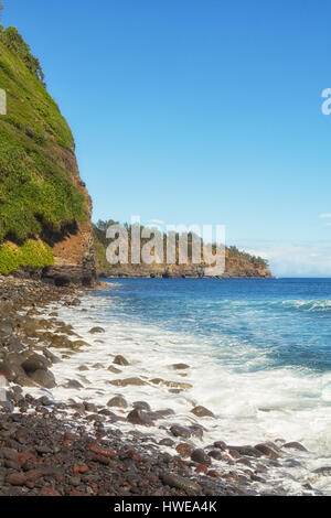 Portrait orientation of rocky Hawaiian beach on a sunny day from the rocky beach of Pololu Valley. Stock Photo