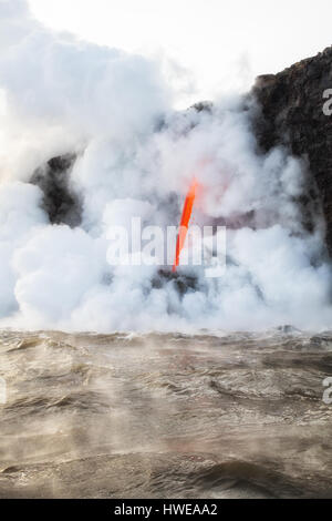 Steam rises off Pacific Ocean at the Kamokuna lava entry on the Big Island of Hawaii. Portrait orientation, Stock Photo