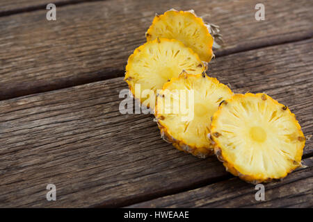 Close-up of pineapple slices on wooden table Stock Photo