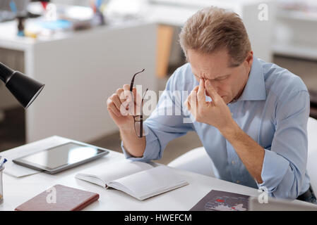 Tired office worker bowing his head Stock Photo